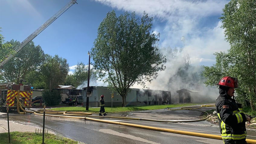 Firefighters spraying water on a trailer fire