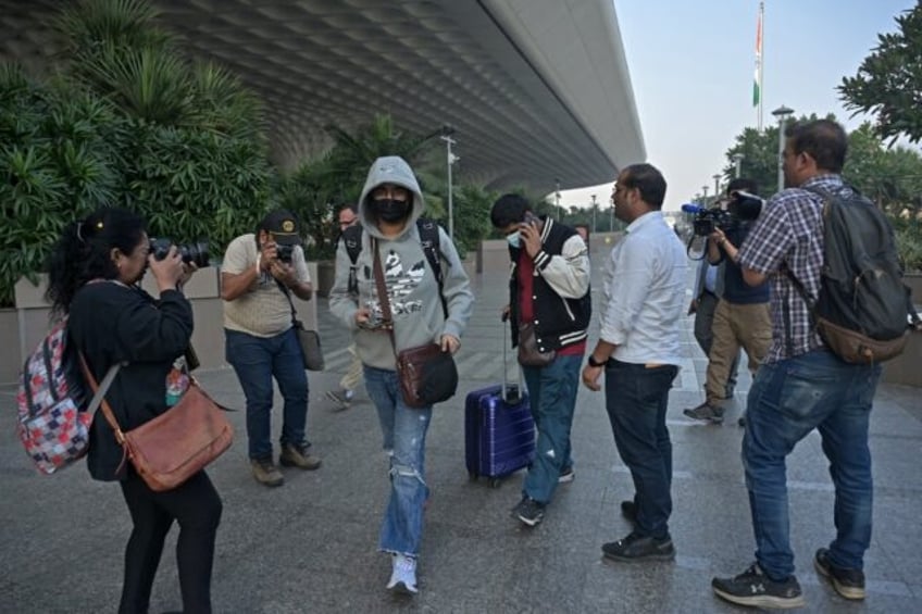 Passengers (C) arriving from France refused to speak to waiting journalists at Mumbai airport