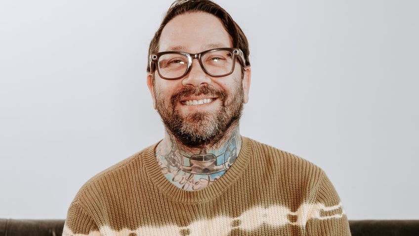 Dave Shapiro wears khaki sweater with glasses