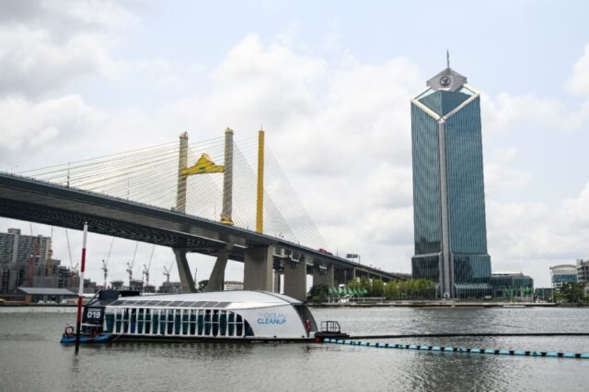 The boat-like structure uses the river current to funnel plastic into the barge's waiting