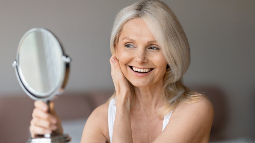 Older woman hand mirror