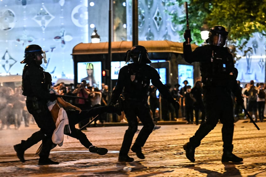 TOPSHOT - Anti-riot police officers detain a person as Paris Saint-Germain supporters celebrate after PSG won the UEFA Champions League final football match between Paris Saint-Germain (PSG) and Inter Milan held in Munich, on the Champs-Elysees avenue in Paris on May 31, 2025. (Photo by LOU BENOIST / AFP) (Photo by LOU BENOIST/AFP via Getty Images)