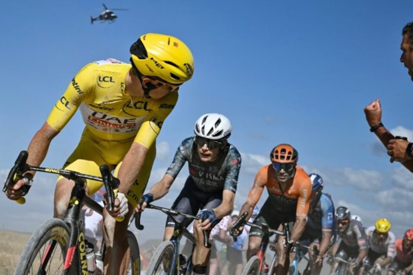 Tadej Pogacar looks back on Jonas Vingegaard (2nd L) during a gravel section of the ninth