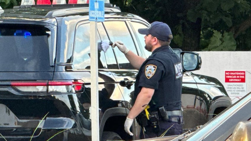 Police swabbing an SUV for fingerprints