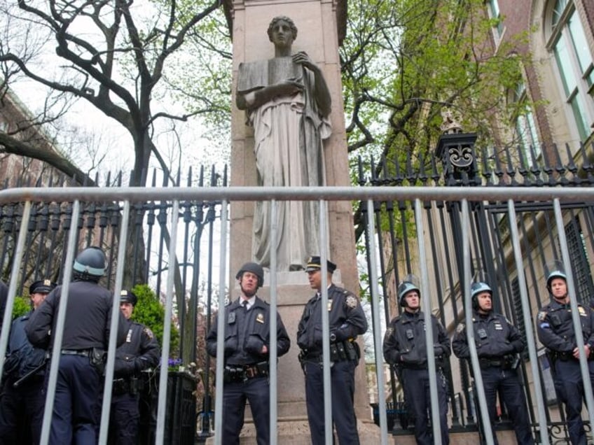 FILE - New York City police in riot gear stand guard outside the Columbia University campu