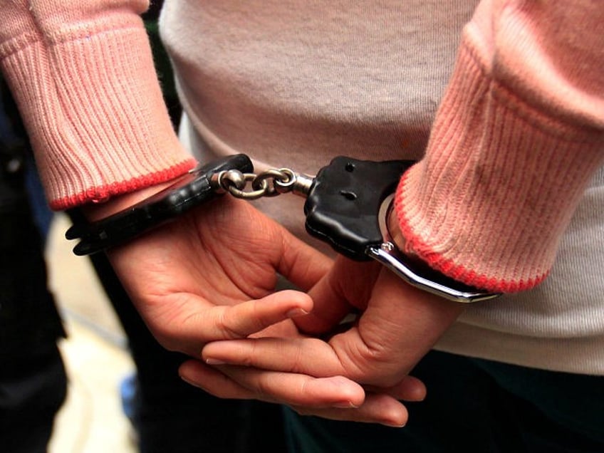 An unidentified female Colombian suspect in handcuffs is presented to the press after her