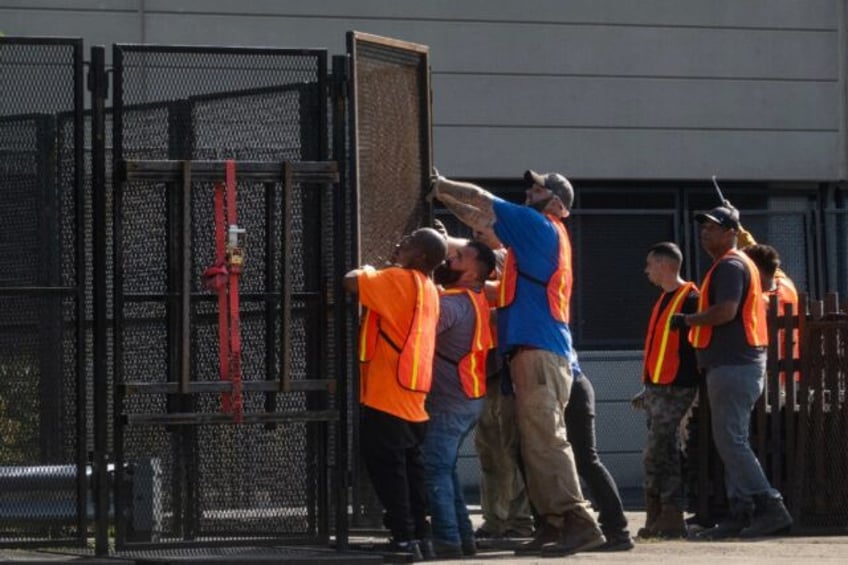 Workers install security fencing around the United Center as they prepare for the start of