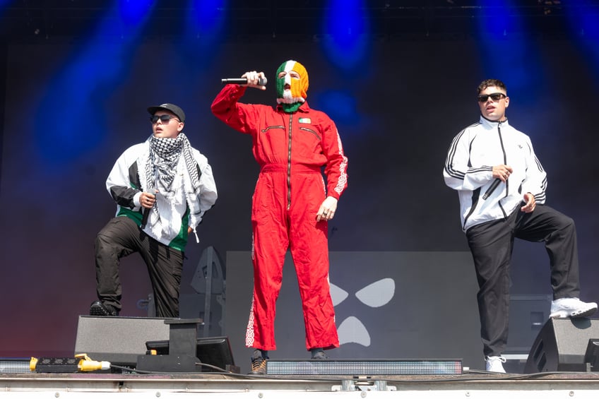 GLASTONBURY, ENGLAND - JUNE 28: Mo Chara, DJ Provaí and Móglaí Bap of Kneecap perform on the West Holts stage during day four of Glastonbury festival 2025 at Worthy Farm, Pilton on June 28, 2025 in Glastonbury, England. Established by Michael Eavis in 1970, Glastonbury has grown into the UK's largest music festival, drawing over 200,000 fans to enjoy performances across more than 100 stages. In 2026, the festival will take a fallow year, a planned pause to allow the Worthy Farm site time to rest and recover. (Photo by Ki Price/WireImage)