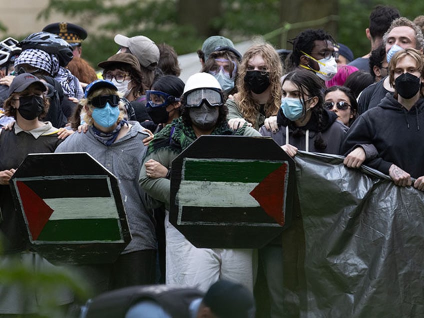 Demonstrators prepare to confront police who are planning to break up an encampment on the