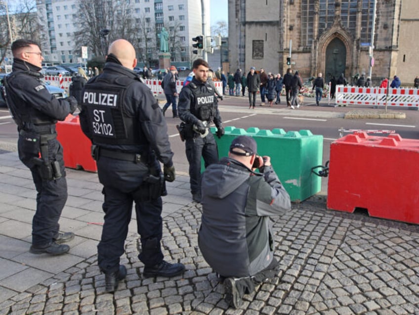 24 December 2024, Saxony-Anhalt, Magdeburg: Police officers stand in front of concrete bar