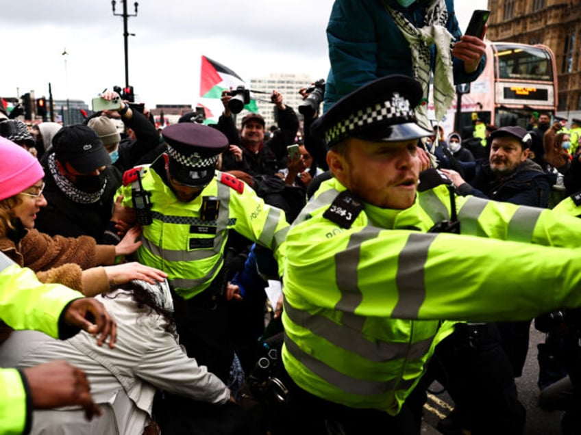 Metropolitan (MET) Police officers clash with protesters during a Pro-Palestinian demonstration in front of the Palace of Westminster, in central London, on January 6, 2024, calling for a ceasefire now in the war in Gaza. Thousands of civilians, both Palestinians and Israelis, have died since October 7, 2023, after Palestinian …