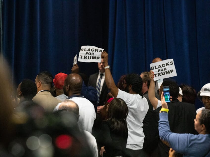 Attendees hold signs that read "Blacks For Trump" during the 'Black Voices for Trump' laun