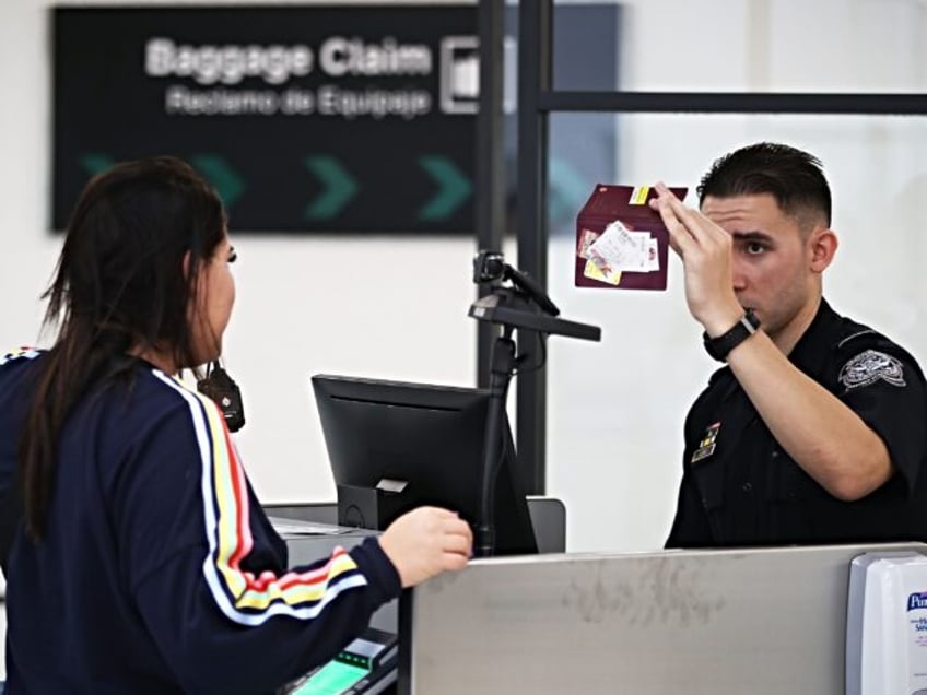 MIAMI, FL - FEBRUARY 27: A U.S. Customs and Border Protection officer uses facial recognit