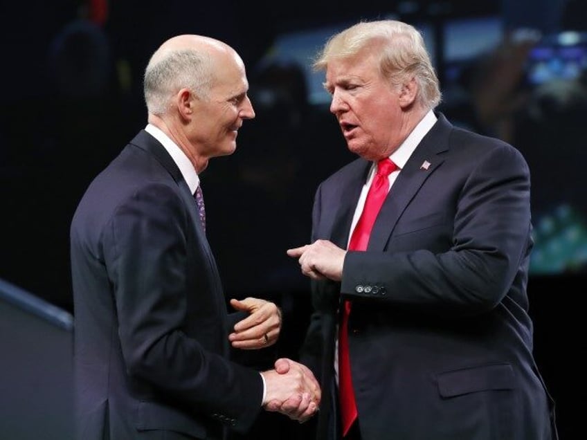 Gov. Rick Scott, R-Fla., left, speaks with President Donald Trump as he arrives to speak a