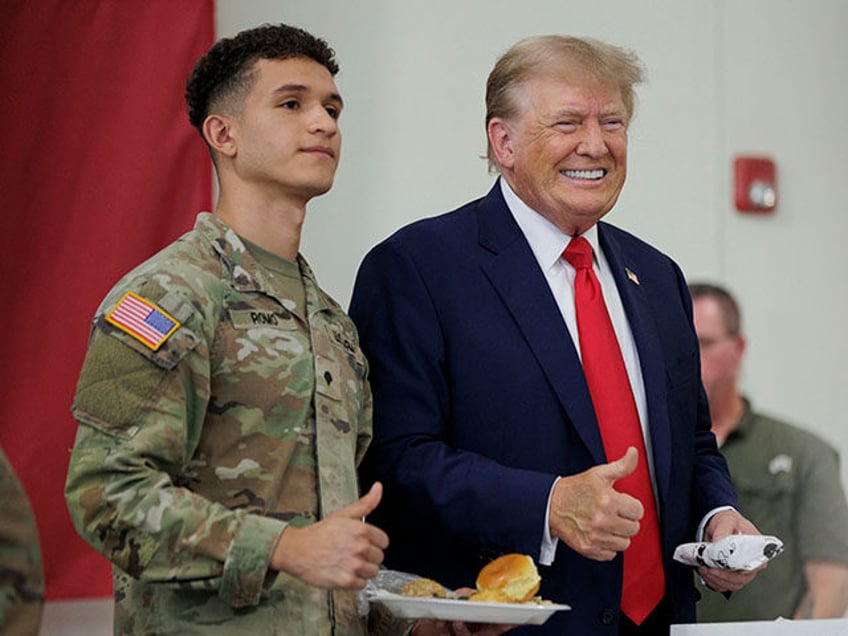 Former US president Donald Trump poses for a photo with a service member at the South Texa