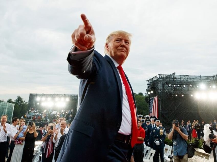 President Donald Trump points to the cheering crowd as he leaves an Independence Day celeb