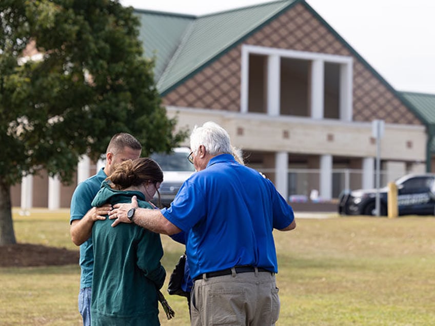 Chaplains pray with a student and parent outside of Apalachee High School on September 5,