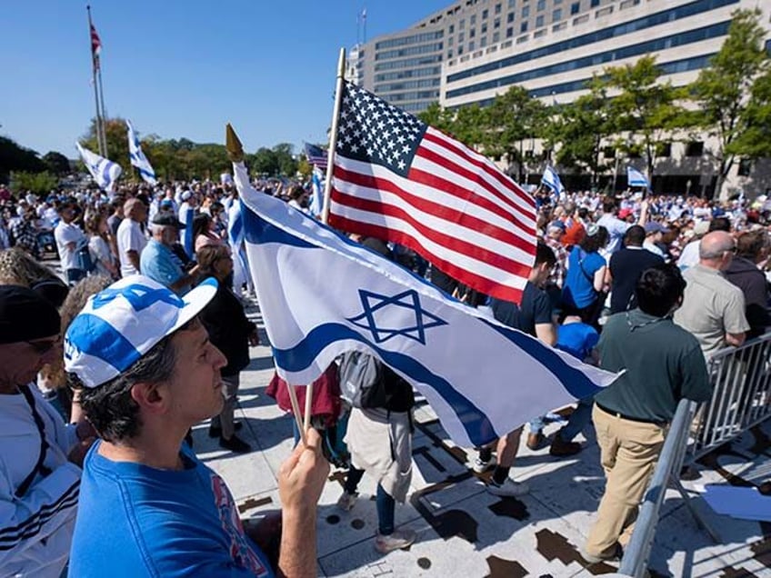 Darren Margolis, of Maryland, waves American and Israeli flags during a rally supporting Israel at Freedom Plaza, Friday, Oct. 13, 2023, in Washington. (AP Photo/Manuel Balce Ceneta)