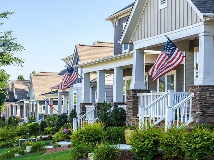 American Flags hang from the front porch of a row of upscale Victorian-style homes in cele