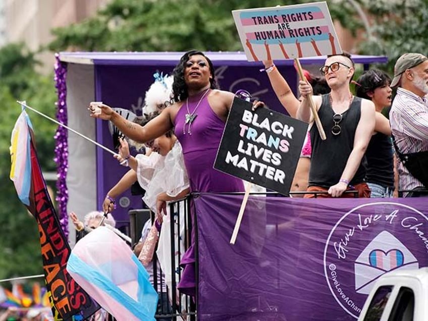 Participants hold signs reading "Black Trans Lives Matter" and "Trans Right