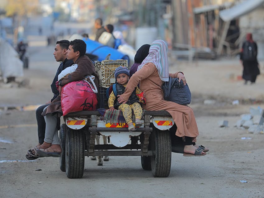 Palestinians in the Al-Mughraqa area of Gaza City, Gaza, travel with what belongings they