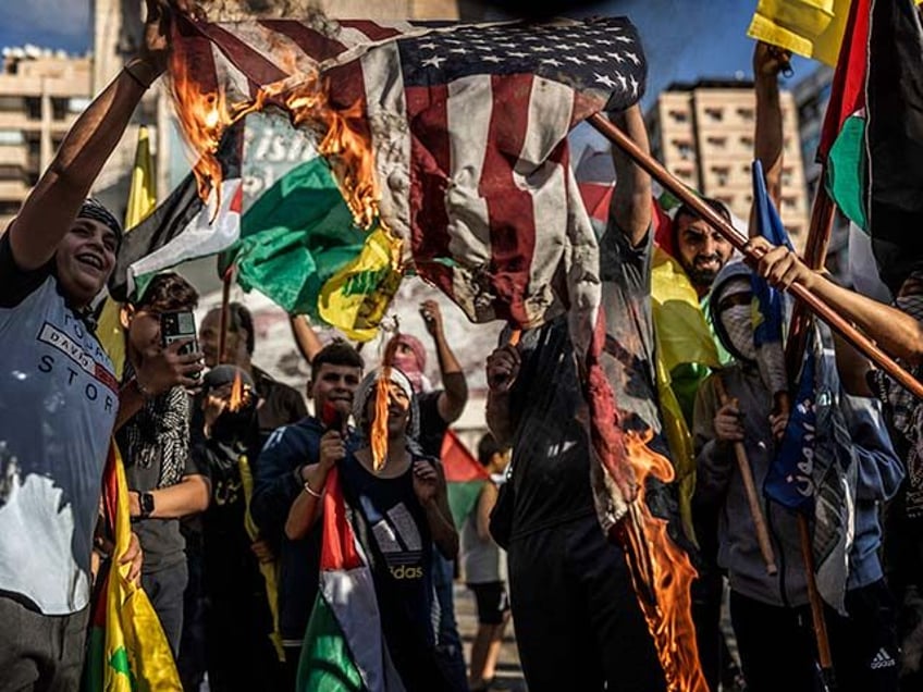 Young supporters of Hezbollah burn a US flag during a rally in support of Palestinians in Gaza on October 20, 2023 in Beirut, Lebanon. There has been an escalation in pro-Palestinian demonstrations worldwide, amid the renewed fighting between Israel and Hamas, which launched a surprise attack in southern Israel on …