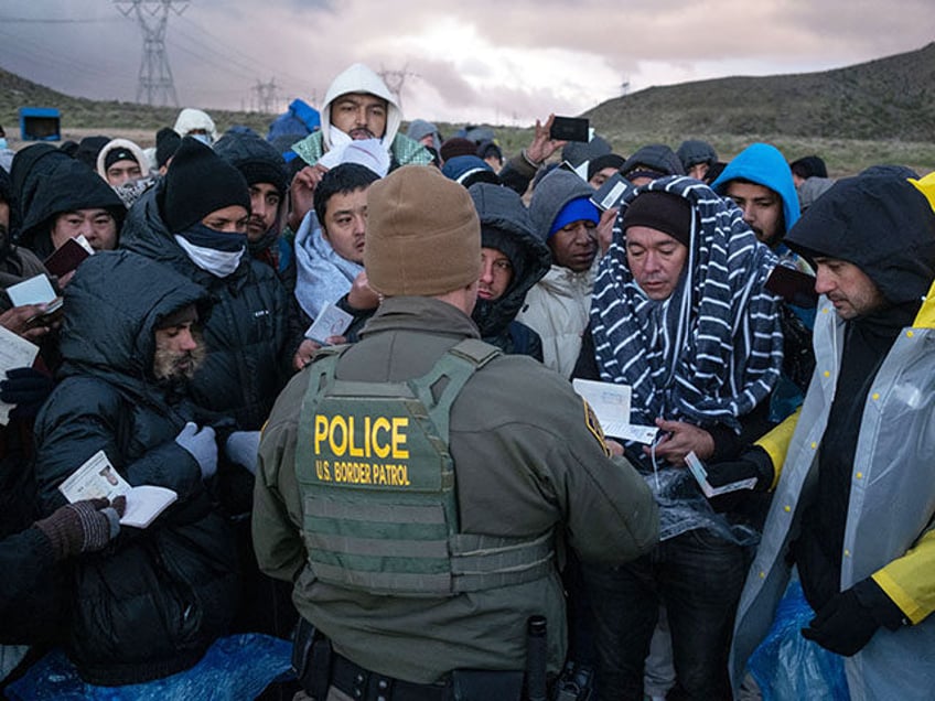 Asylum seekers rush to be processed by border patrol agents at an improvised camp near the