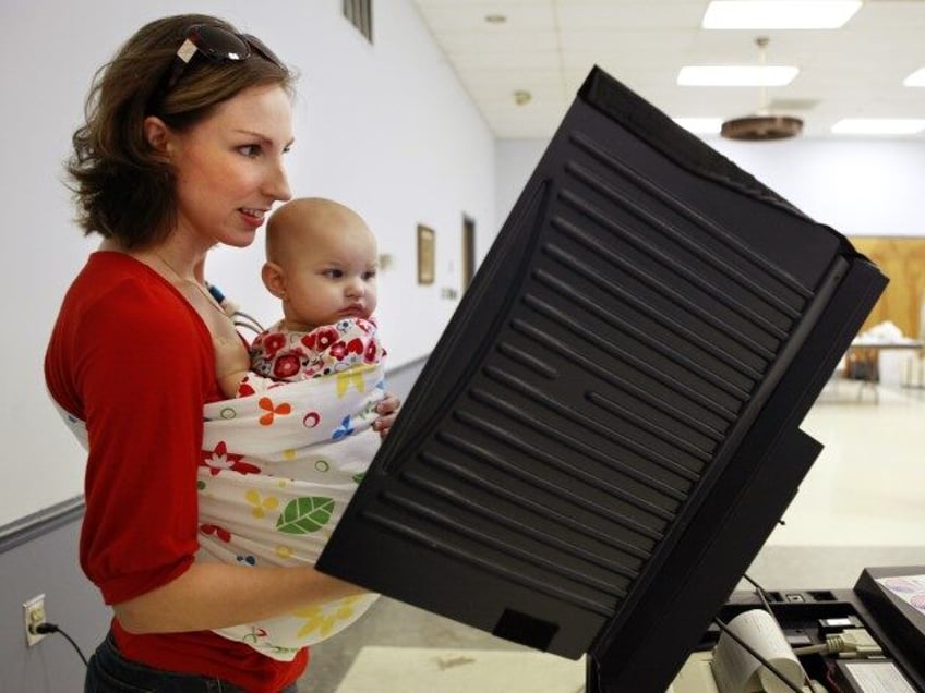 Liesl Balatsenko holds her daughter Sasha Balatsenko, 1, while voting at the Elk Lodge in