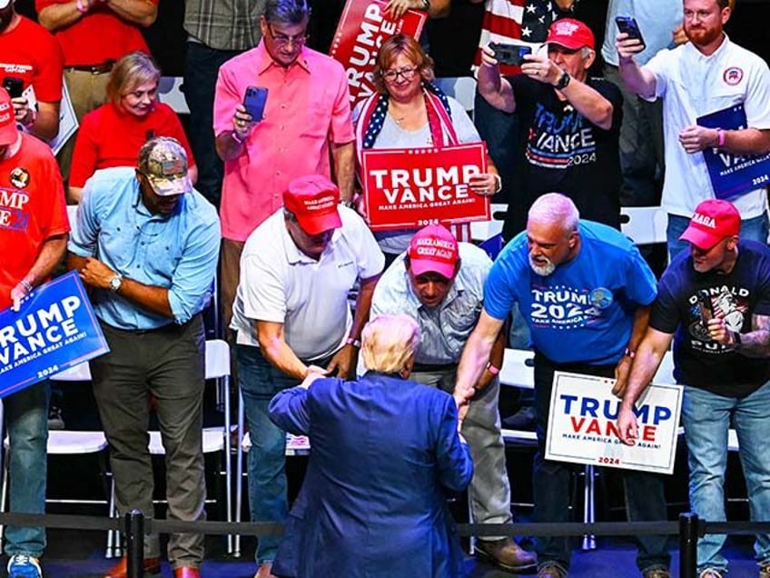 Former US President and Republican presidential candidate Donald Trump greets supporters a