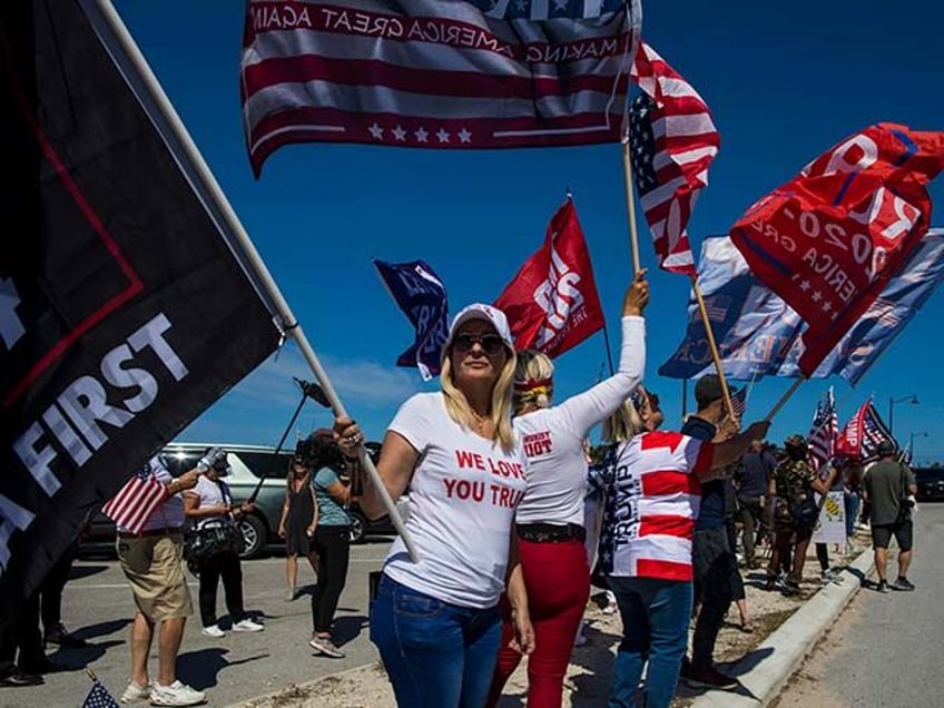 Supporters of former President Donald Trump display flags outside of Trump's Mar-a-La