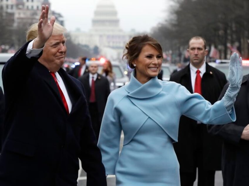 President Donald Trump waves as he walks with first lady Melania Trump during the inaugura