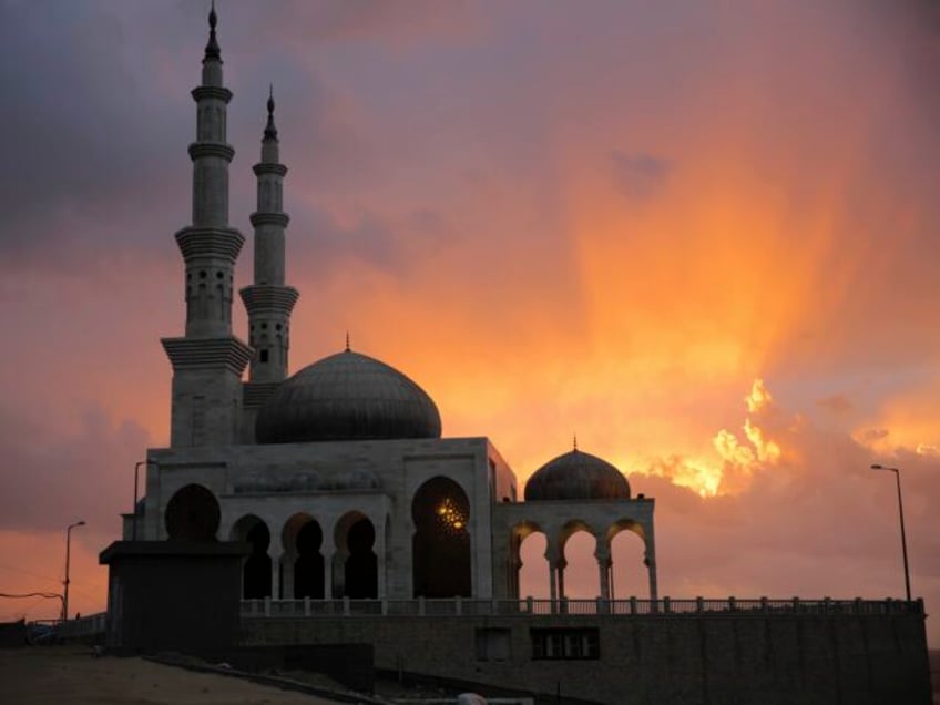 A Palestinian man walks into the beach mosque to attend the noon prayer during cloudy and