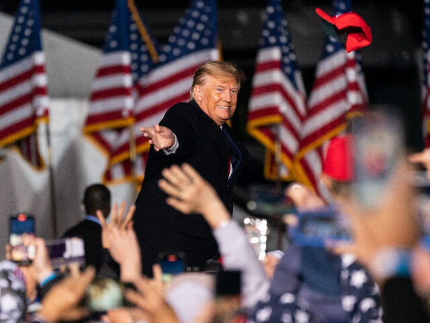 Former U.S. President Donald Trump tosses a hat into the crowd at a 'Save America&#03