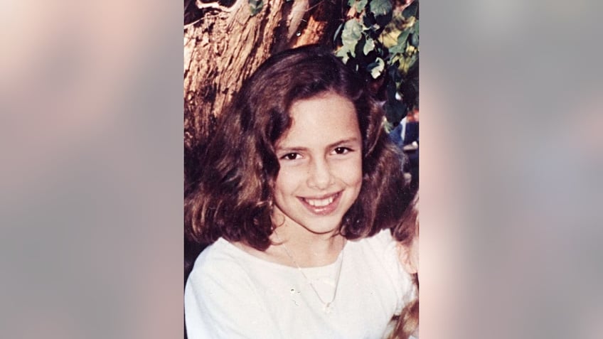 Polly Klaas poses near a tree