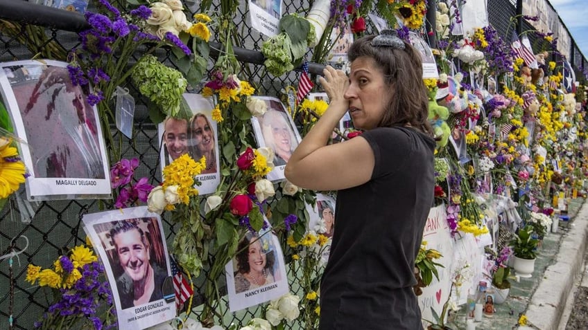 A woman cries at a memorial for the Surfside victims