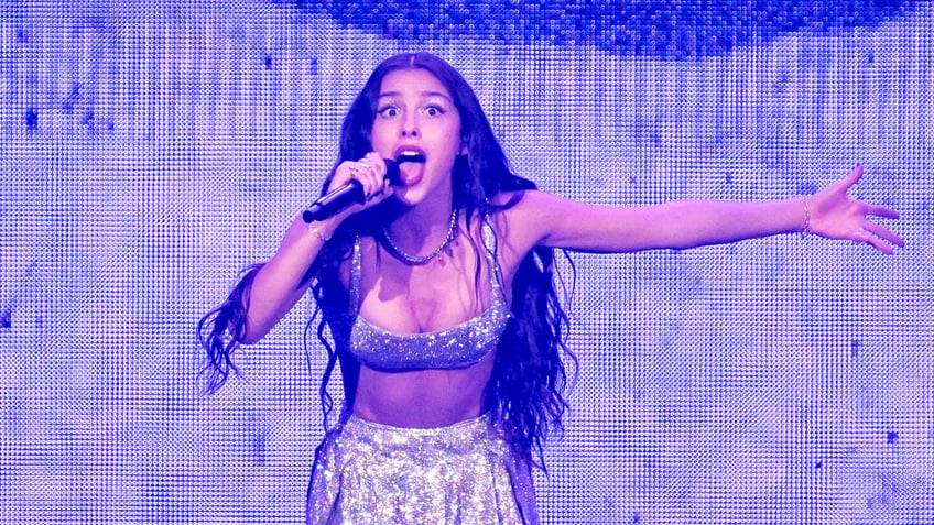 Olivia Rodrigo sings in a silver sparkle outfit