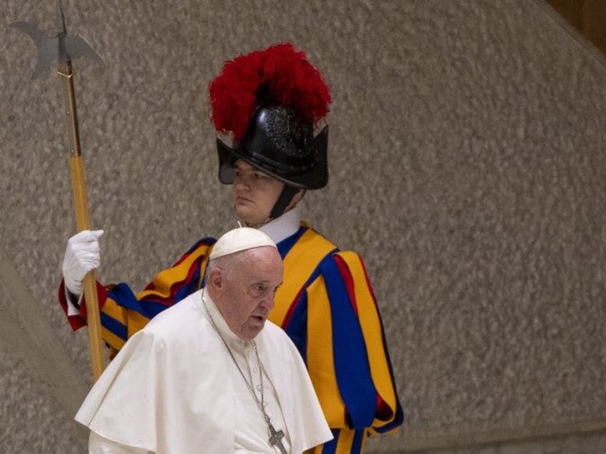 Pope Francis walks by a pontifical Swiss guard as he arrives for an audience with the 'Doctors with Africa' University College For Aspiring Missionary Doctors (CUAMM) organization in the Paul VI Hall at The Vatican, Saturday, Nov. 19, 2022. (Domenico Stinellis/AP)