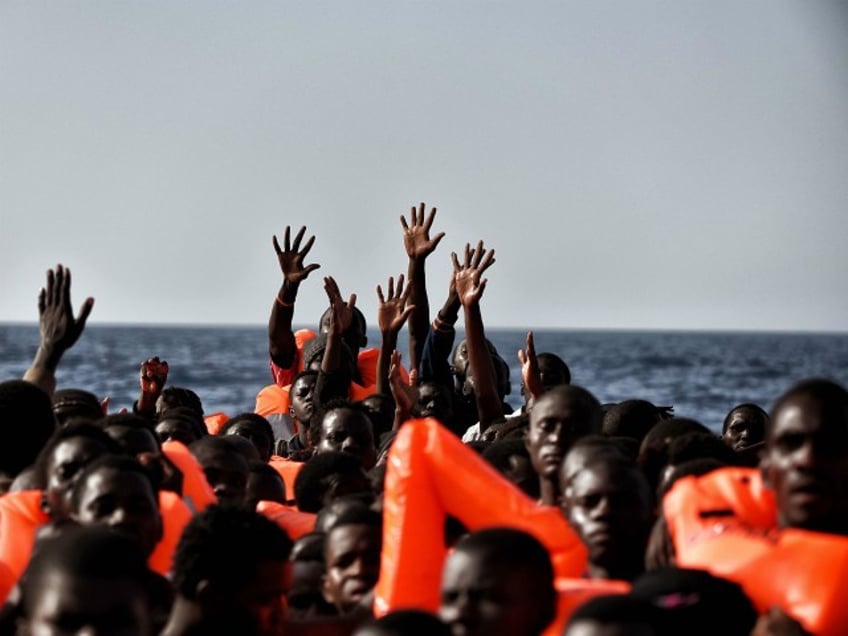 TOPSHOT - Migrants wait to be rescued as they drift in the Mediterranean Sea some 20 nautical miles north off the coast of Libya on October 3, 2016. Italy coordinated the rescue of more than 5,600 migrants off Libya, three years to the day after 366 people died in a sinking that first alerted the world to the Mediterranean migrant crisis. / AFP PHOTO / ARIS MESSINIS (Photo credit should read ARIS MESSINIS/AFP/Getty Images)