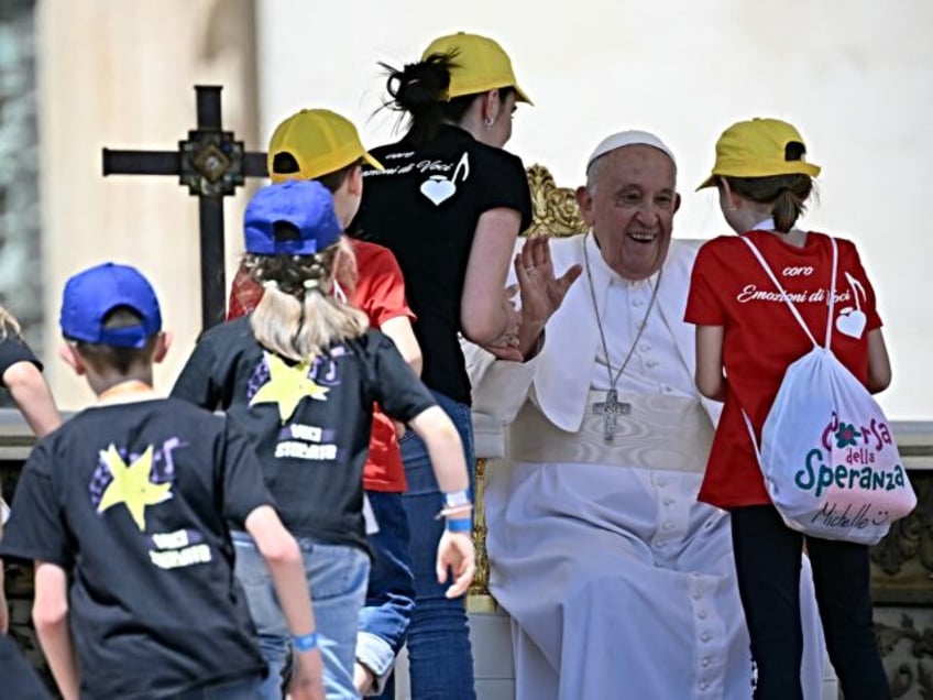 Pope Francis greets children during a mass on World Children's Day at St Peter's Basilica