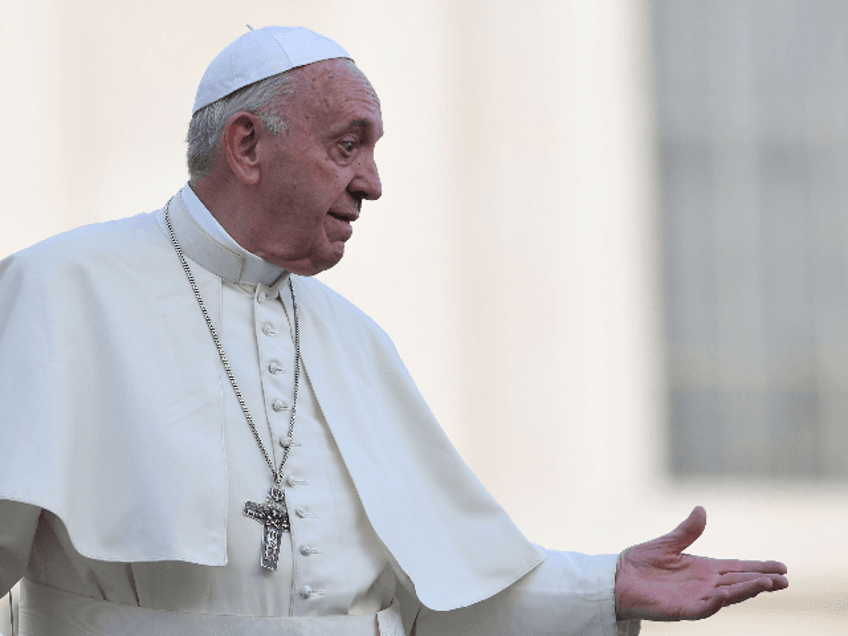 Pope Francis gestures to worshipers from the popemobile car as he leaves at the end of the