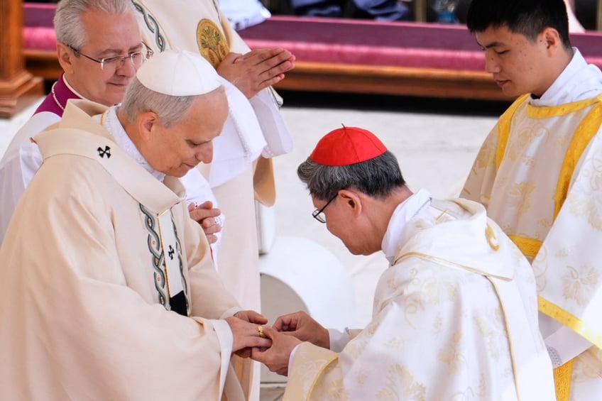 Filipino cardinal Luis Antonio Gokim Tagle puts the Fisherman's Ring on a finger of Pope Leo XIV during a mass for the beginning of his pontificate, in St Peter's square in The Vatican on May 18, 2025. (Photo by Jacquelyn Martin / POOL / AFP) (Photo by JACQUELYN MARTIN/POOL/AFP via Getty Images)