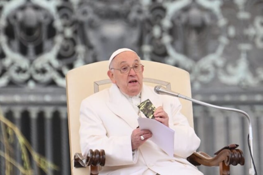 Pope Francis holds a small new Testament from a soldier who died in Ukraine during his wee