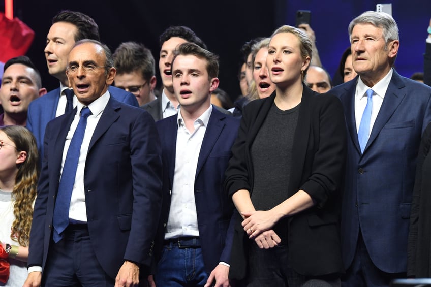 Media pundit and "Reconquete" party presidential candidate Eric Zemmour (2nd L), next to Reconquete! vice-president Guillaume Peltier (L) President of "Generation Z" movement Stanislas Rigault (C), French far-right politician Marion Marechal (2nd R) and political ally Philippe de Villiers (R) sing the national anthem at the end of his meeting at the Palais des Sports in Paris, on April 7, 2022, as part of the political campaign, a few days before the first round of France's presidential election. (Photo by bERTRAND GUAY / AFP) (Photo by BERTRAND GUAY/AFP via Getty Images)