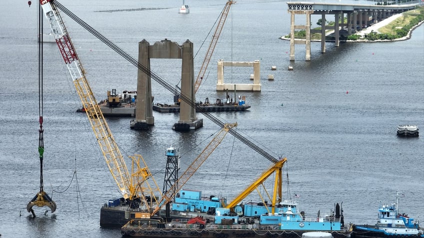 In an aerial view, salvage crews continue to clean up wreckage from the collapse of the Francis Scott Key Bridge in the Patapsco River.