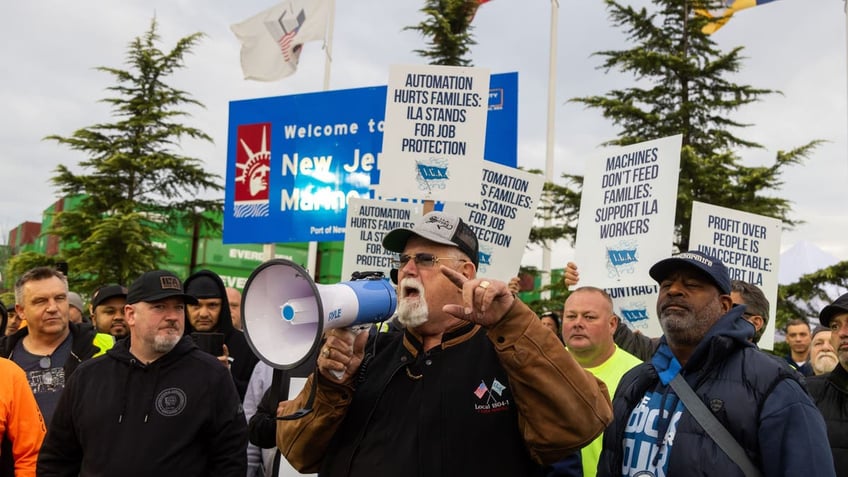 Harold Daggett speaks through a megaphone at a dockworkers strike