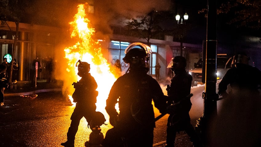 Portland police seen near a fire during Portlands summer of riots and protests in 2020