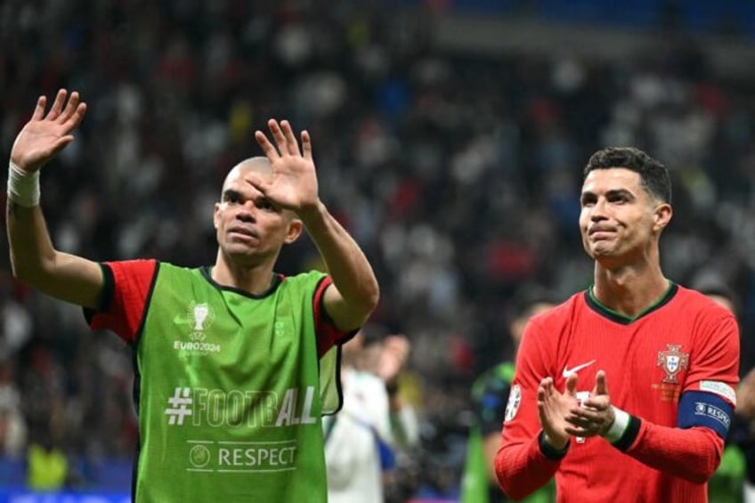 Pepe (L) and Cristiano Ronaldo celebrate after Portugal progress past Slovenia at Euro 202