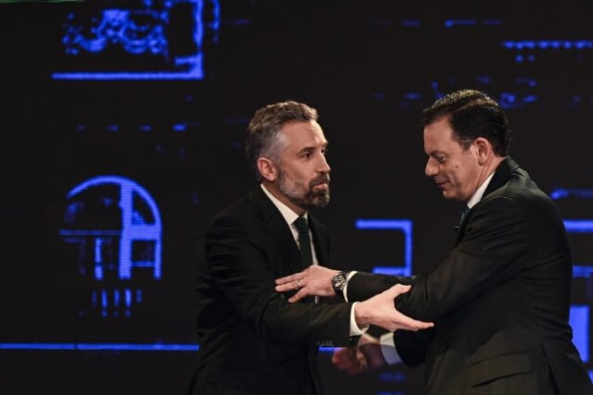 Socialist Party leader Pedro Nuno Santos (L) greets Luis Montenegro (R) before a TV debate