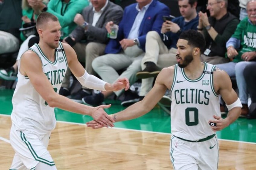 Kristaps Porzingis high fives Boston teammate Jayson Tatum during the Celtics' victory ove