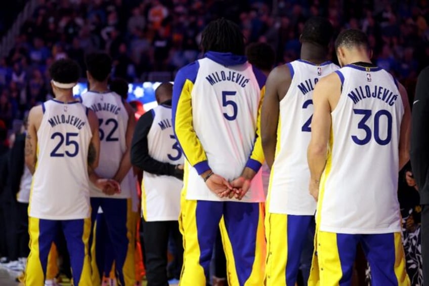 Stephen Curry, right, and other players on the Golden State Warriors wear the name of the late assistant coach Dejan Milojevic on the back of their jerseys after postponed games that the league announced new dates for on Friday